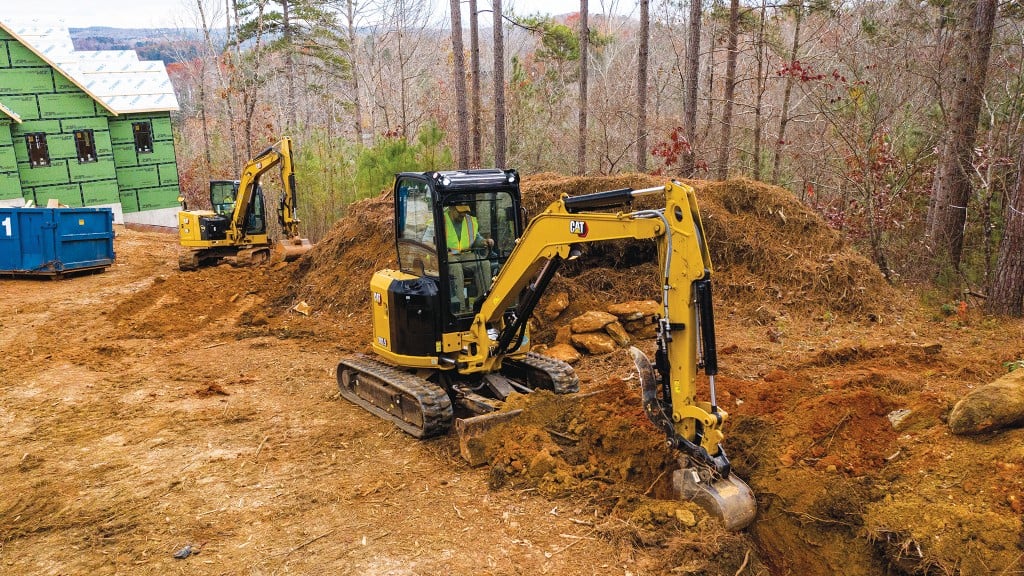 Two mini excavators digging and clearing soil on a bush building site